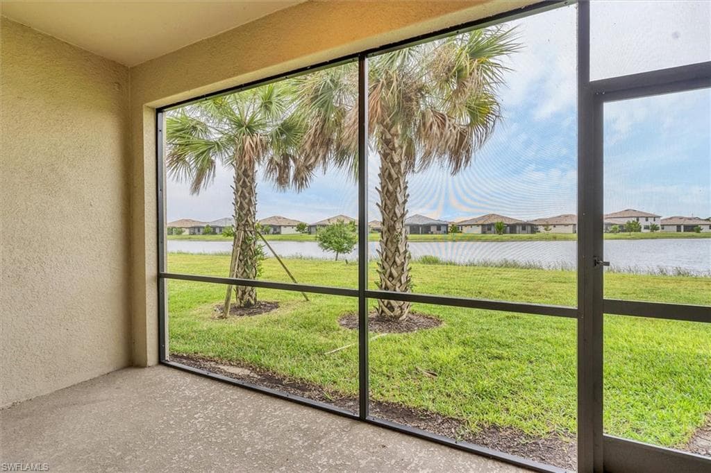 Unfurnished sunroom featuring a residential view and a water view