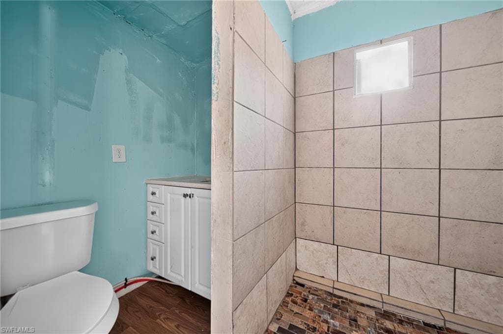 Shower enclosure featuring large format wall tiles and a mosaic tile floor