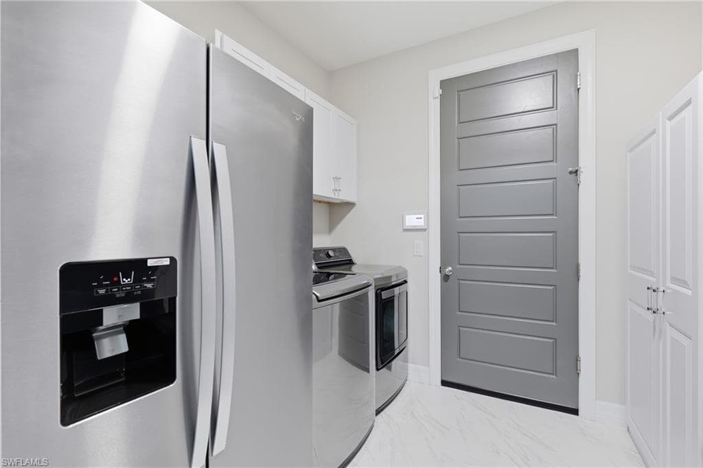 Well appointed laundry room with built-in cabinetry and storage