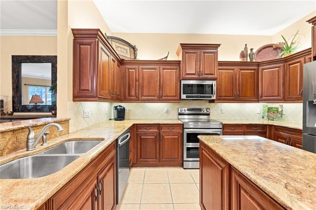 Elegant kitchen featuring rich wood cabinetry with raised-panel doors, dual stainless steel sinks, and granite countertops throughout