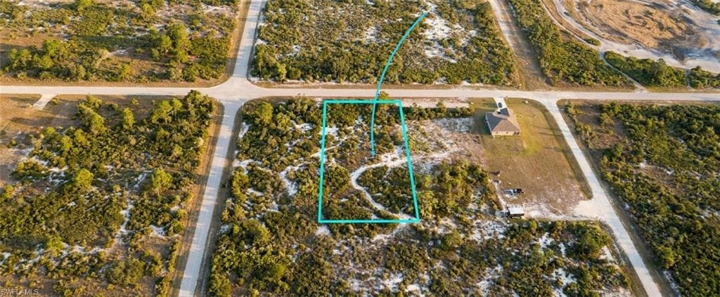 Expansive undeveloped land parcel with surrounding paved roads