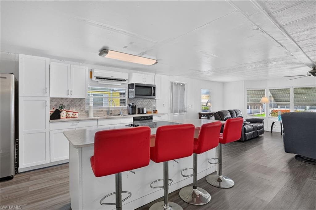 Contemporary kitchen featuring white cabinetry, light-toned countertops, and a full stainless steel appliance package