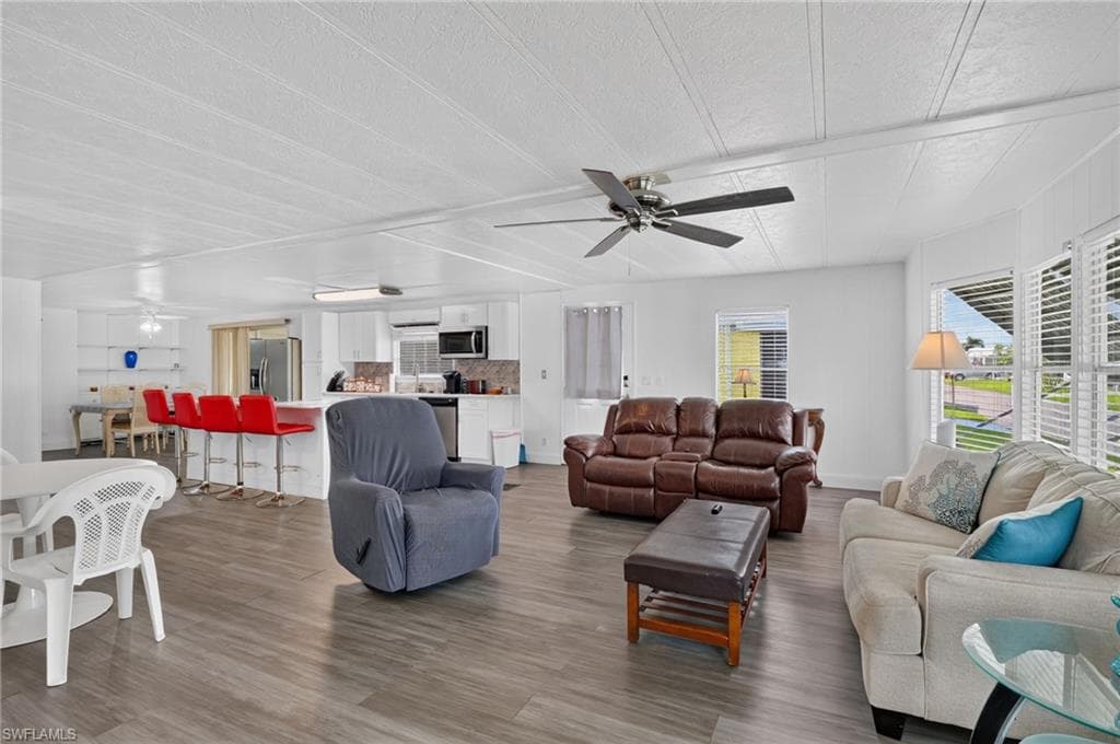 Open-concept living area featuring wood-finish flooring and a ceiling fan