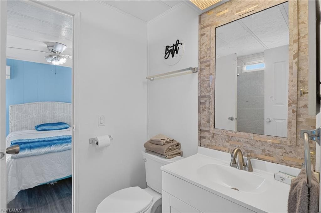 Bathroom featuring a white vanity with an integrated sink, brushed nickel faucet, and a large mirror framed by decorative tile