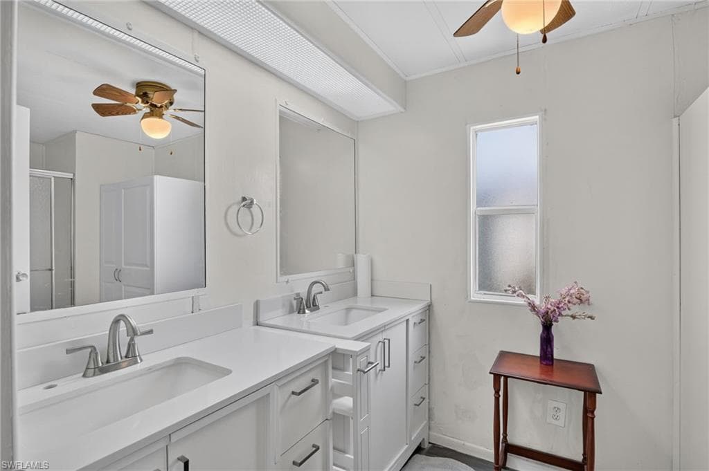 Double vanity featuring white cabinetry and countertops
