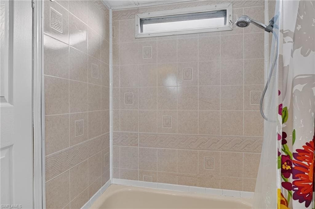 Bathtub with ceramic tile surround featuring decorative accents