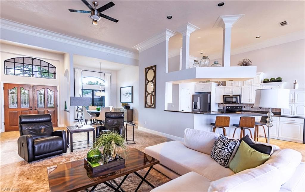 Spacious living area featuring high ceilings, crown molding, and recessed lighting