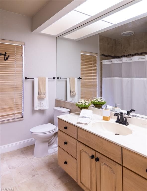 Bathroom featuring a wood-finish vanity with black hardware, a light-toned countertop, and an integrated sink with a matte black faucet