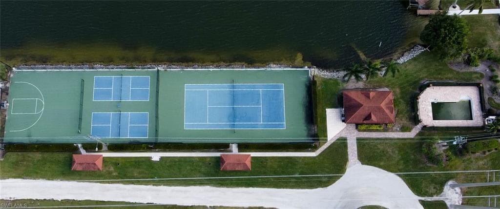 Waterfront recreational area featuring multiple sports courts, a covered pavilion, and an outdoor swimming pool