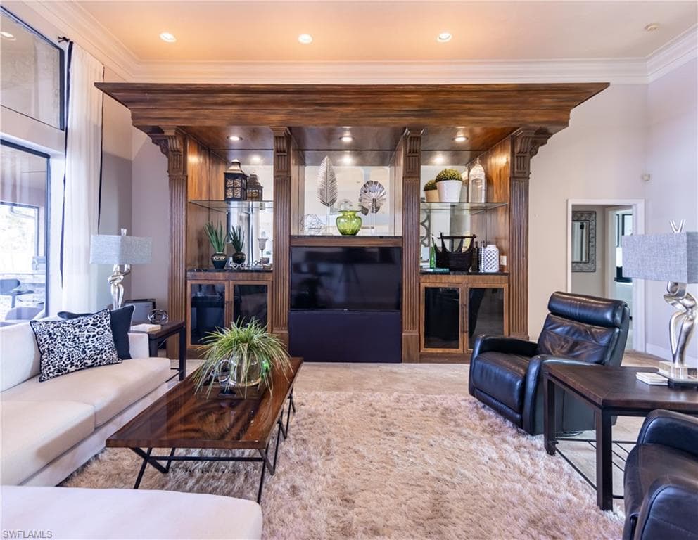 Built-in entertainment center featuring wood-finish cabinetry, glass shelving, and integrated lighting