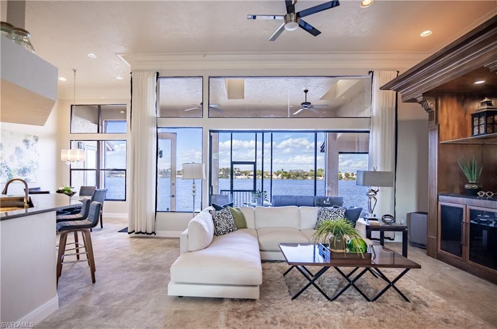 Expansive living area with large-format tile flooring and floor-to-ceiling windows overlooking a body of water