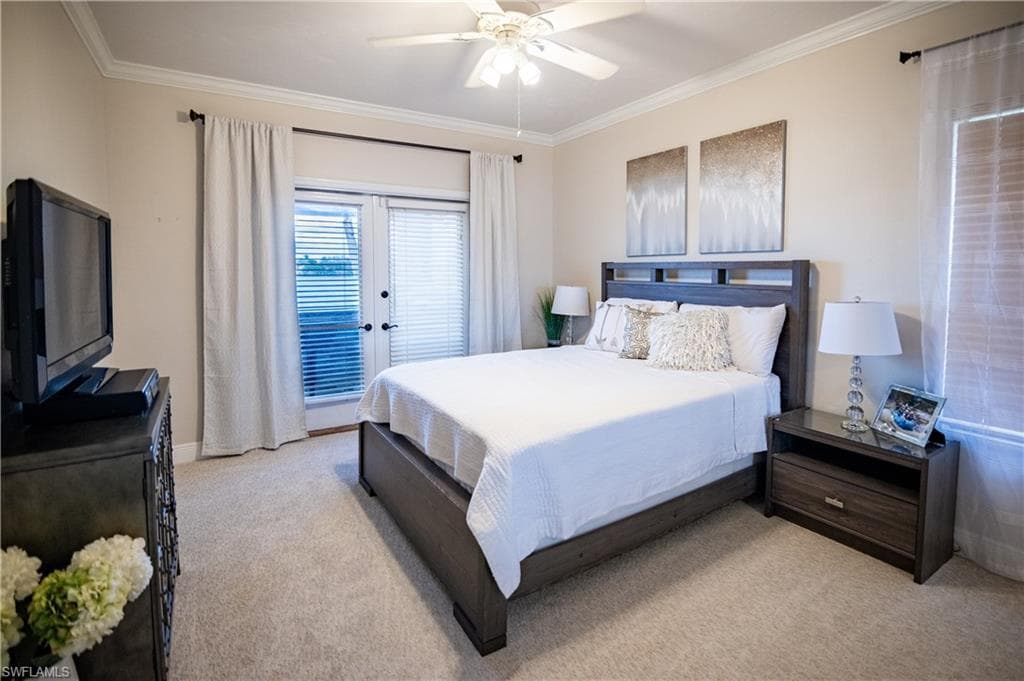 Carpeted room featuring a ceiling fan, crown molding, and double French doors with blinds