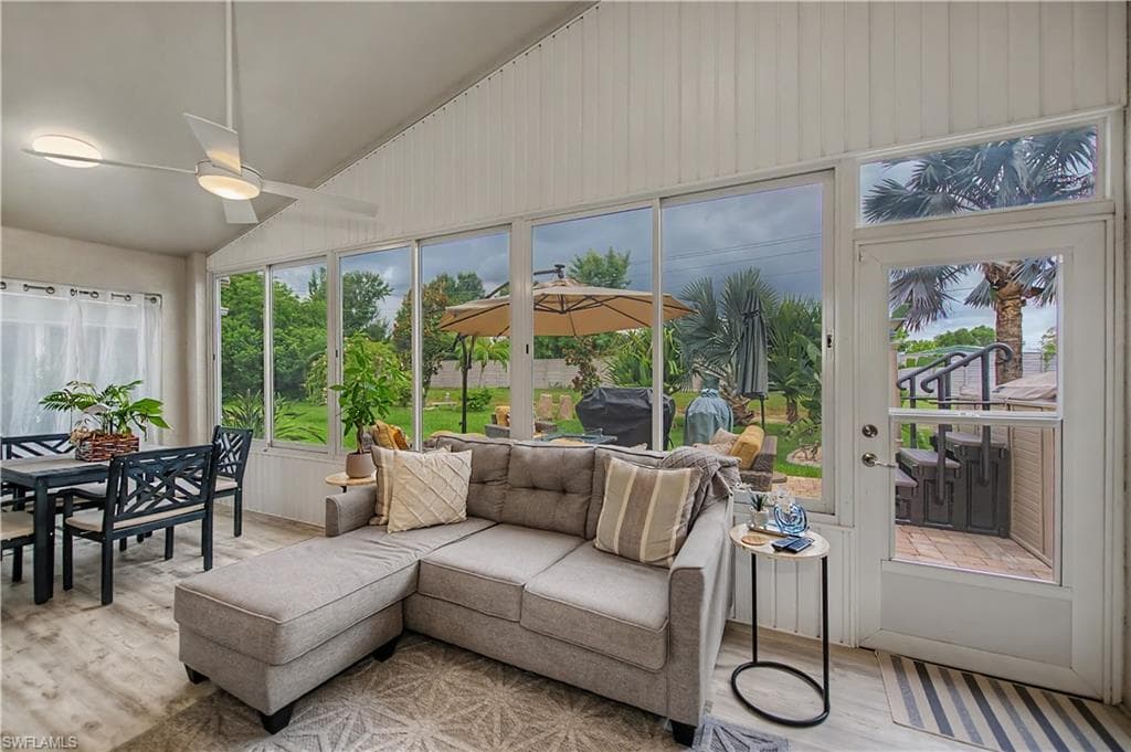 Screened-in porch featuring a vaulted ceiling and an attached ceiling fan