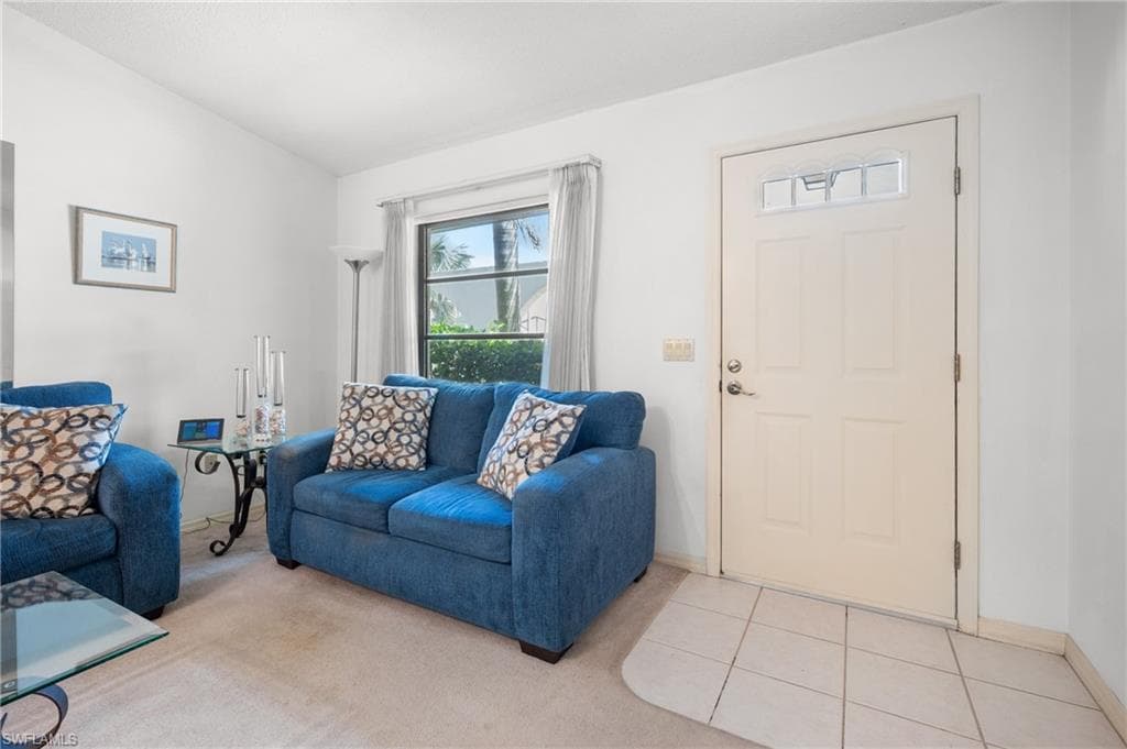 Entryway featuring a panel door with decorative glass inserts and light-toned tile flooring