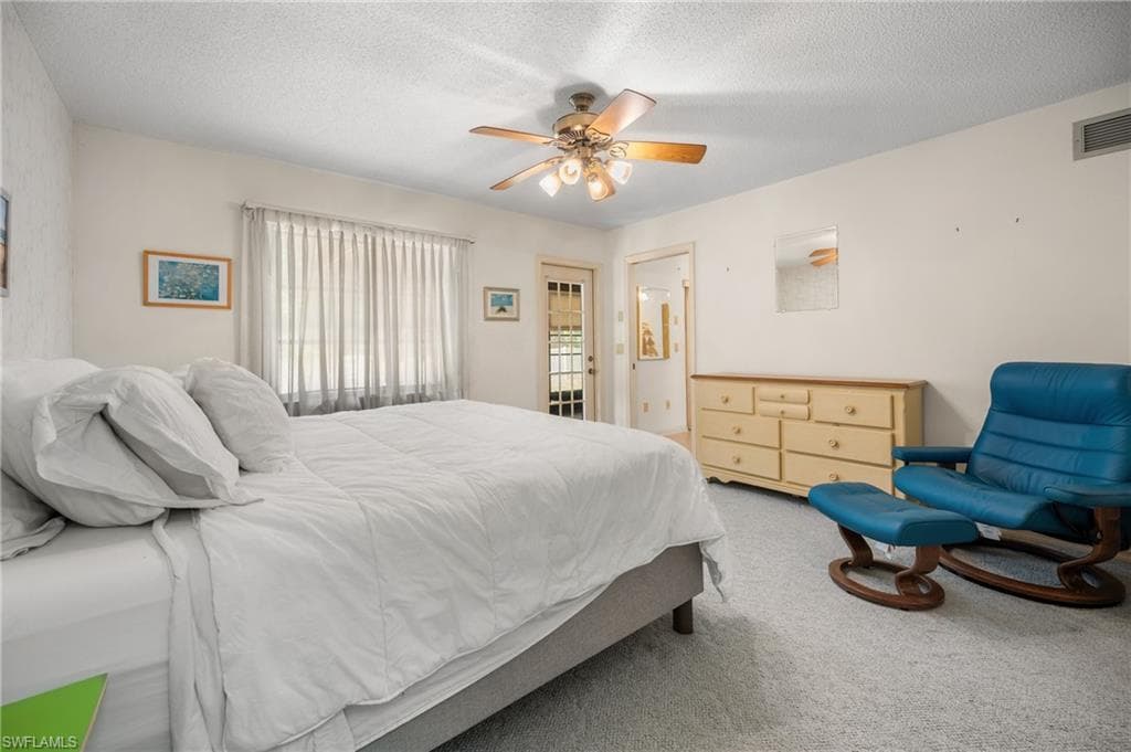Spacious room featuring light-colored walls, textured ceiling, and neutral-toned carpeting
