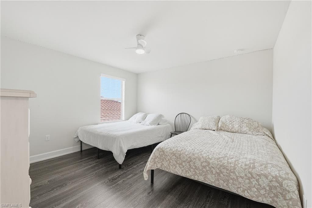 Bright room featuring wood-finish flooring, a white ceiling fan with integrated lighting, and a window with blinds