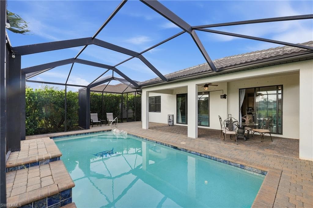 Screened enclosure housing a rectangular swimming pool with integrated steps