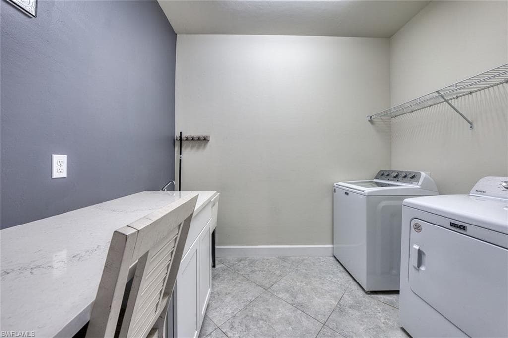 Utility room featuring a built-in countertop, undermount sink with faucet, tiled flooring, and wall-mounted shelving