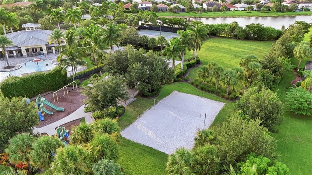 Community amenities featuring a sand volleyball court, playground with multiple slides, and a recreational building with an outdoor pool