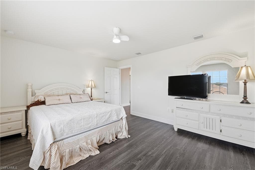 Spacious room featuring dark wood-finish flooring and light-toned walls