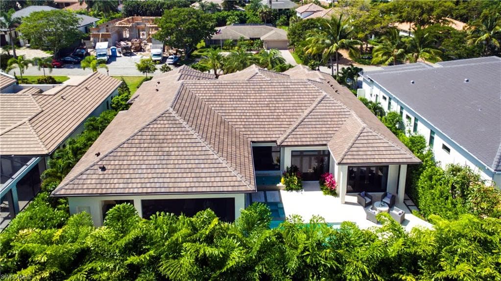Elegant single-story residence showcasing a steeply pitched tile roof with multiple architectural peaks, wide overhanging eaves, and integrated skylights