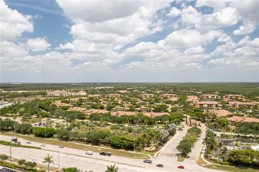 Expansive aerial perspective showcasing a residential community with numerous structures featuring terracotta-style roofing