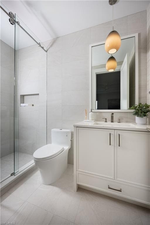 Contemporary bathroom featuring a single vanity with a white cabinet and dark hardware, set against light-toned large format tile flooring and walls