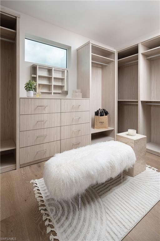 Custom walk-in closet featuring light wood-finish cabinetry, built-in shelving, and integrated drawers