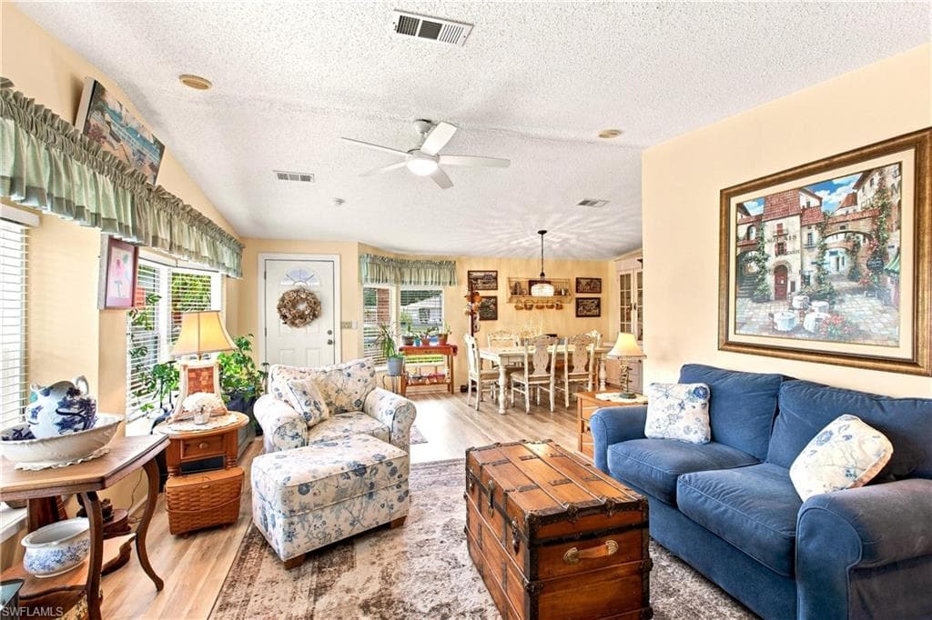Open-concept living area featuring wood-finish flooring, recessed lighting, and a ceiling fan