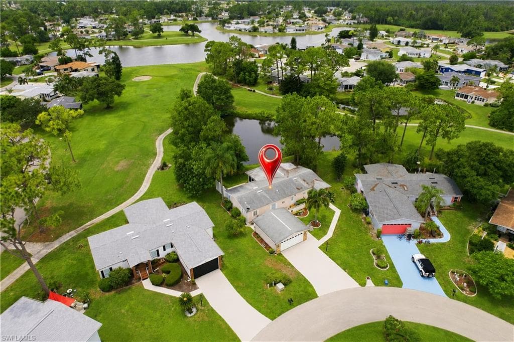 Aerial perspective showcasing a single-story residence with a light-colored exterior and a two-car garage