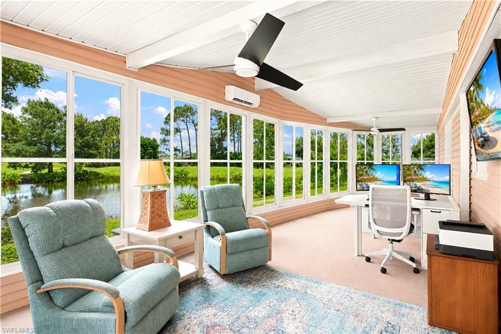 Expansive sunroom featuring a curved wall of large windows, providing abundant natural light and views of the surrounding pond and greenery