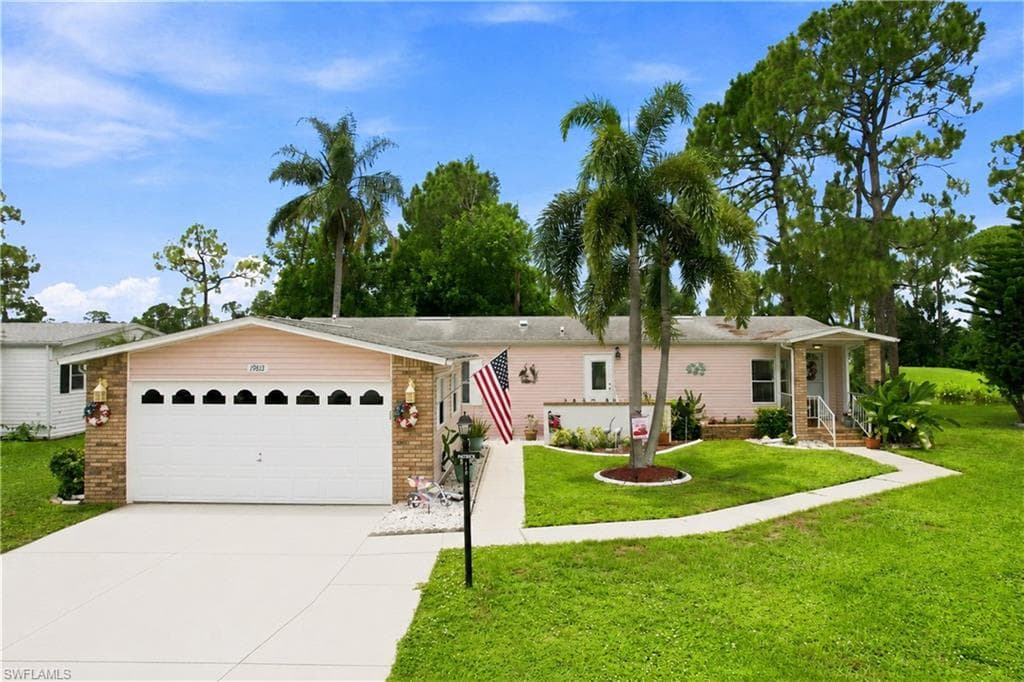 Single-story residence featuring a two-car garage with decorative windows, a paved driveway, and a covered front entry