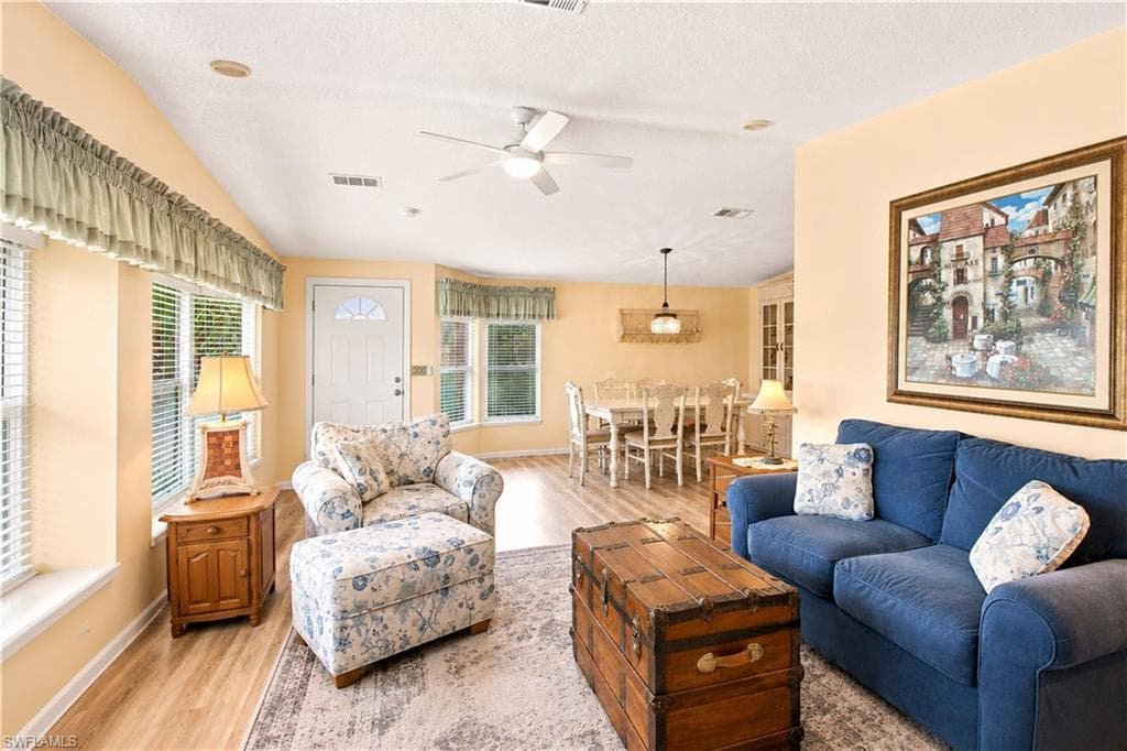 Open concept living area featuring wood-finish flooring and light-toned walls