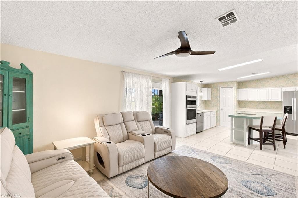 Open concept living area featuring light-toned walls and tile flooring
