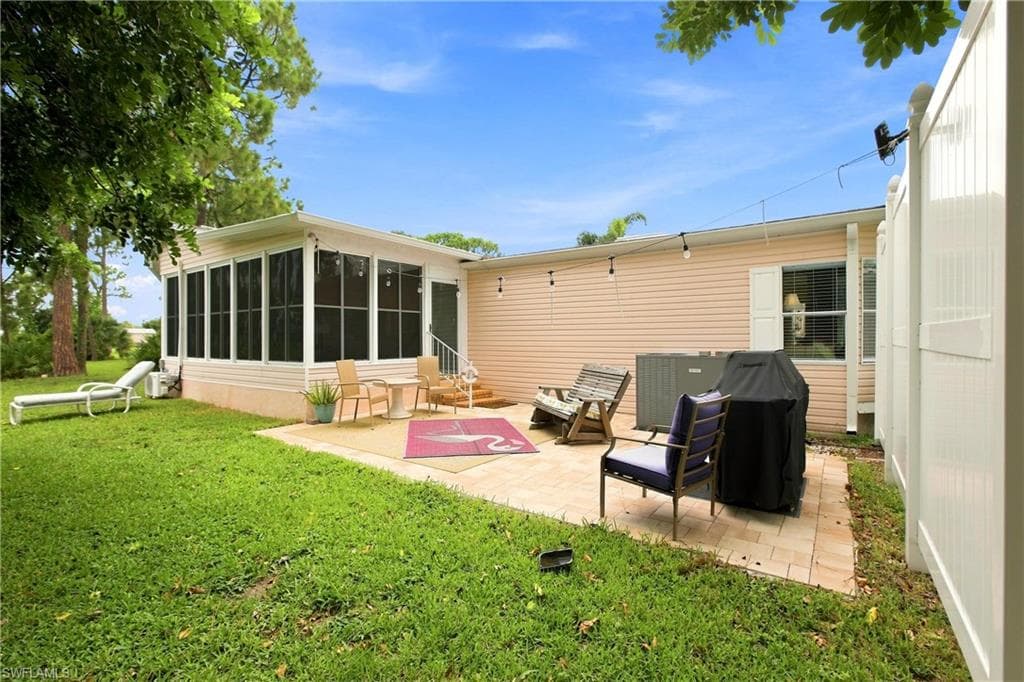 Expansive backyard featuring a screened-in patio, a paver patio area, and a privacy fence