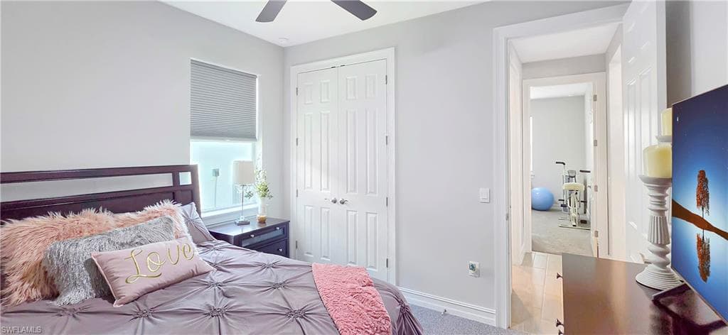 Carpeted bedroom with neutral wall paint and a ceiling fan