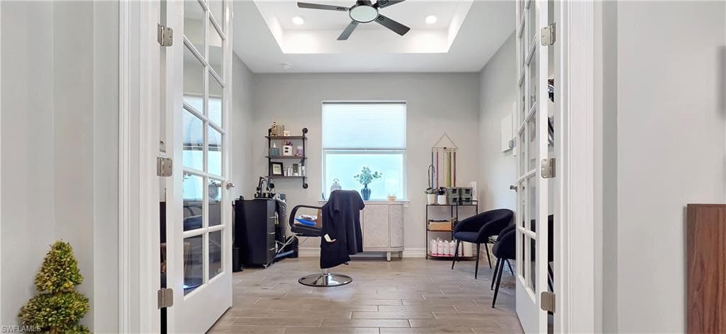 Spacious interior room featuring French doors with glass panels, wood-finish flooring, recessed lighting, and a contemporary ceiling fixture