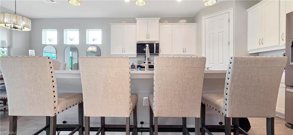 Open-concept living area featuring light wood-finish flooring and a tray ceiling with recessed lighting