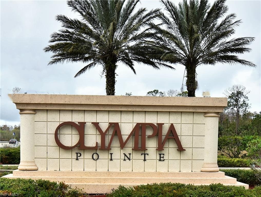 Olympia Pointe community entrance sign featuring decorative blockwork, columnar accents, and prominent metal lettering