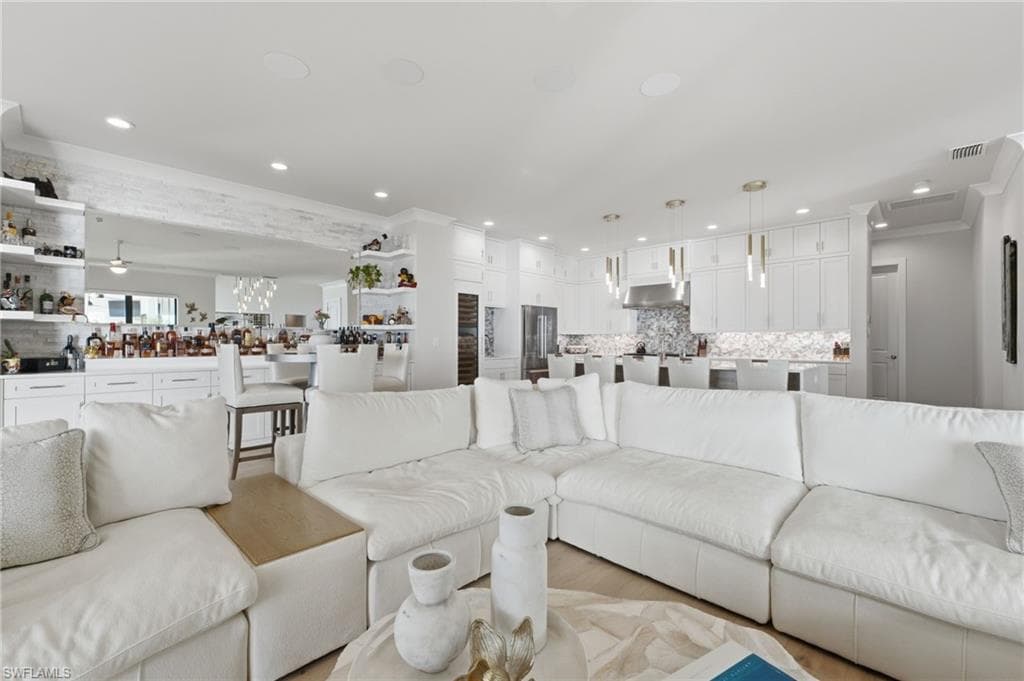 An expansive open-concept design allows the chef’s kitchen, sophisticated living room, and elegant bourbon bar to flow together seamlessly, creating an exceptional setting for effortless entertaining and elevated waterfront living.
