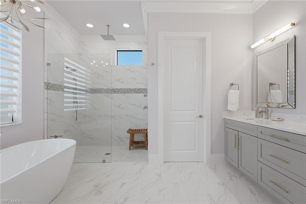 The luxurious primary bath is a serene, spa-inspired sanctuary featuring dual quartz-topped vanities, a private water closet, and an expansive walk-in shower enclosed in seamless glass. Transom windows invite abundant natural light, while a sumptuous soaking tub provides the perfect setting for ultimate relaxation.