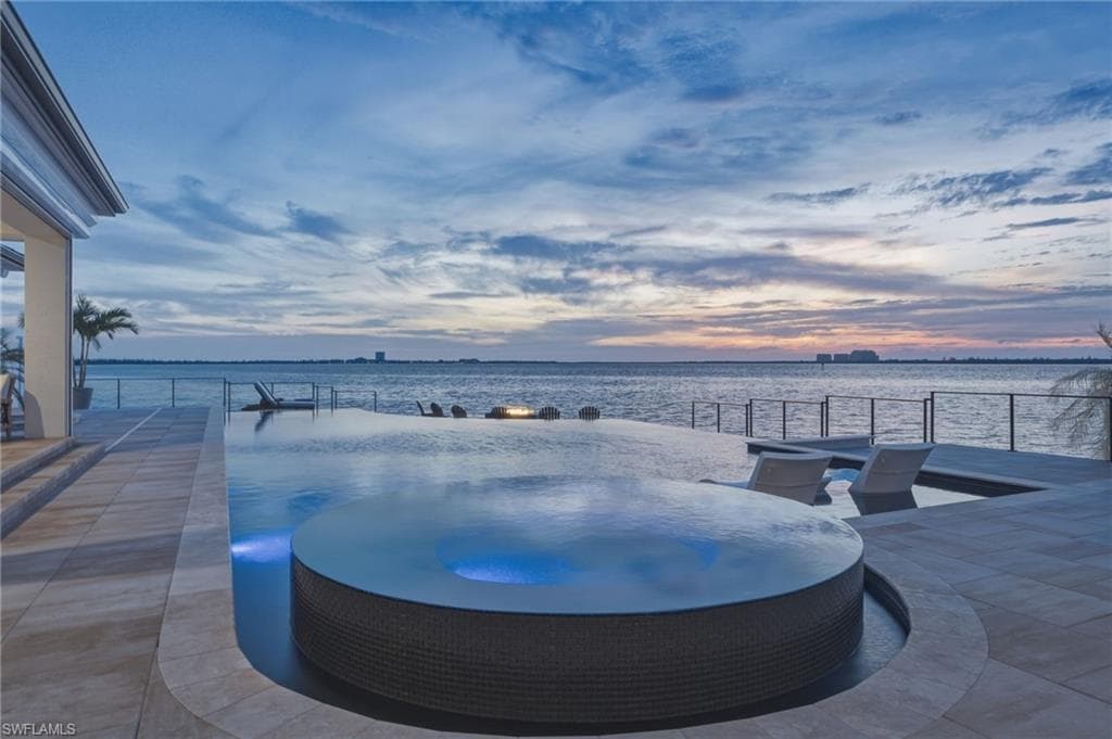 Your private compound offers an unparalleled sense of seclusion, where a spectacular three-sided infinity pool—one of the only of its kind in Fort Myers—seamlessly frames the waterfront beyond. An inviting eight-person spa beckons, creating the perfect setting to unwind and indulge in serene relaxation after a day on the links.
