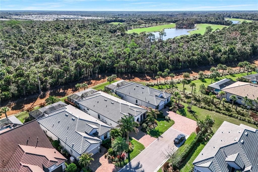 Aerial perspective showcasing residential properties bordering a lush, wooded area