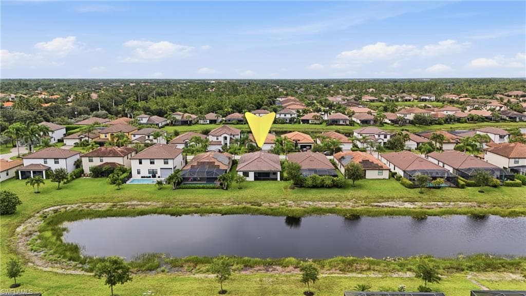 Stunning waterfront estate lot featuring a spacious residence with terracotta tile roofing, situated on expansive grounds overlooking a serene pond