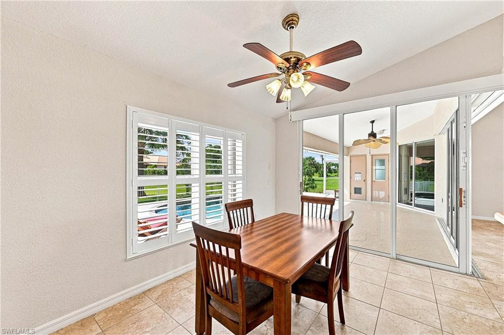 Spacious dining area near the featuring tile flooring, a vaulted ceiling, and an overhead ceiling fan
