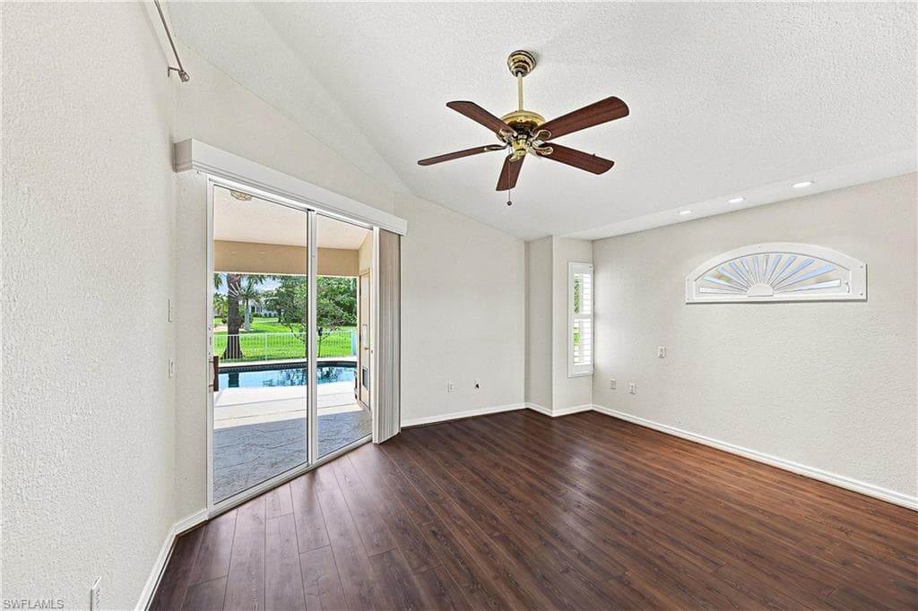 Spacious interior featuring wood-finish flooring, vaulted ceiling, custom plantation shutters, and direct access to a screened-in patio with a pool