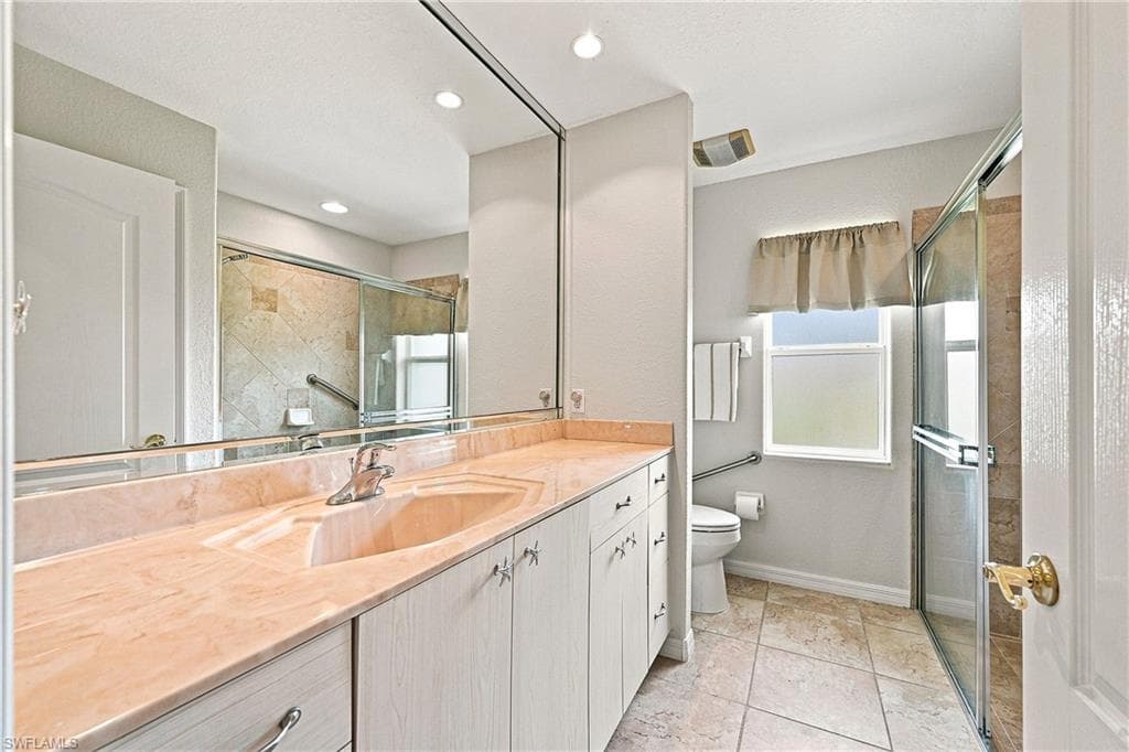 Guest bathroom vanity featuring an integrated sink, expansive mirror, and recessed lighting