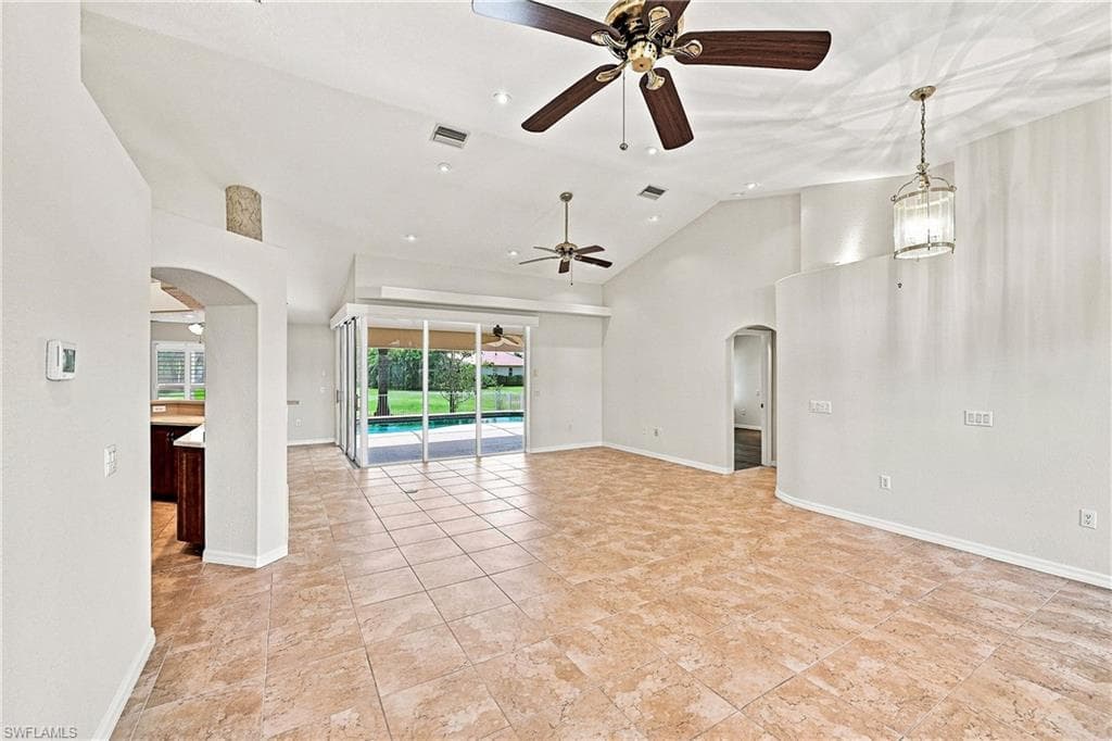 Expansive space for living room and formal dining area, open from the entry foyer to pool patio, with vaulted ceilings, tile floors, ceiling fans, recessed lighting, and ninety-degree 8 ft high sliders opening to the lanai