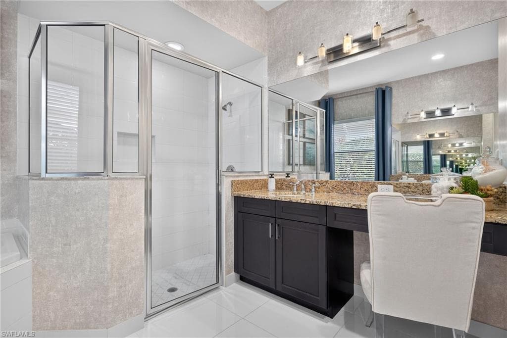 Walk-in shower with clear glass enclosure and white tile surround