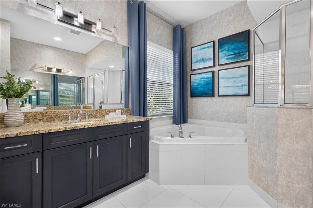 Dual vanity with granite countertop, built-in soaking tub, separate glass-enclosed shower, and water closet.